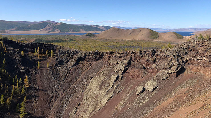 Spectacular Terkhiin Tsagaan Lake is seen in the distance from an ancient extinct volcano - Uran Togoo
